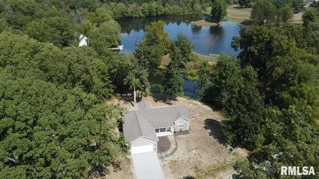 an aerial view of a house with a yard and lake view