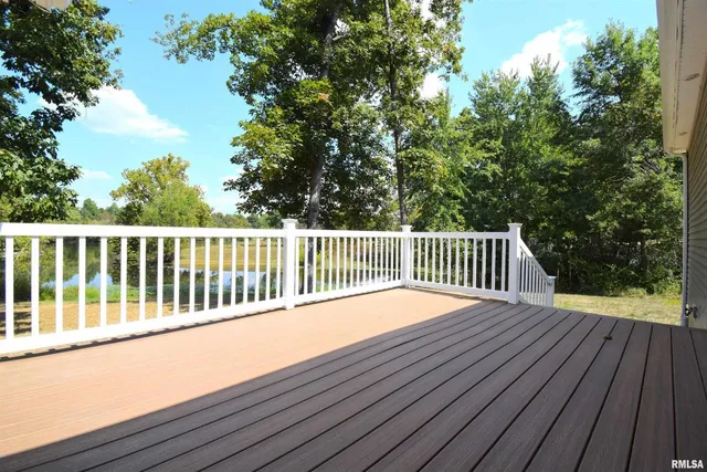 a balcony with wooden floor and trees