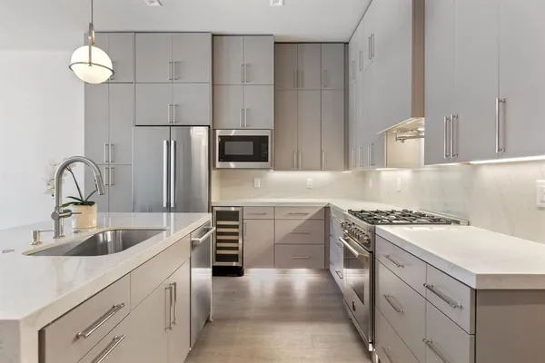a kitchen with refrigerator and chairs