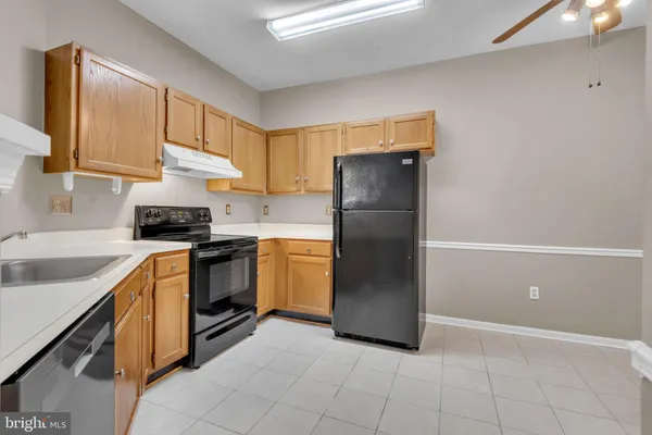 a kitchen with a refrigerator sink and cabinets