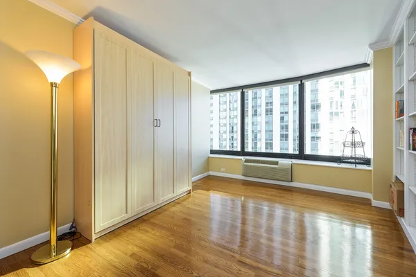 a bedroom with a bed and a large window