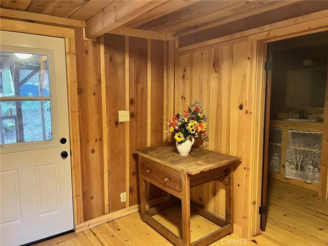 a view of a hallway with wooden floor and front door
