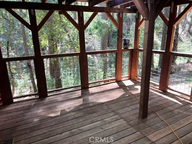 a view of wooden floor and trees in the balcony