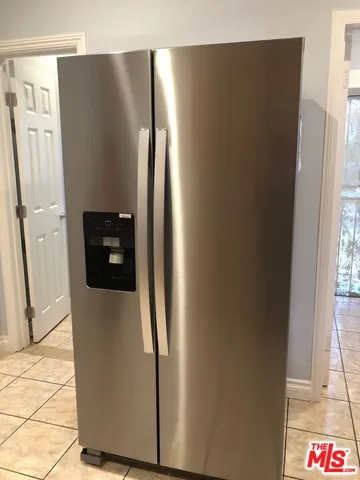 a metallic refrigerator freezer sitting in a kitchen