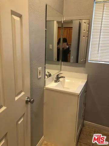 a bathroom with a granite countertop sink and mirror with shower