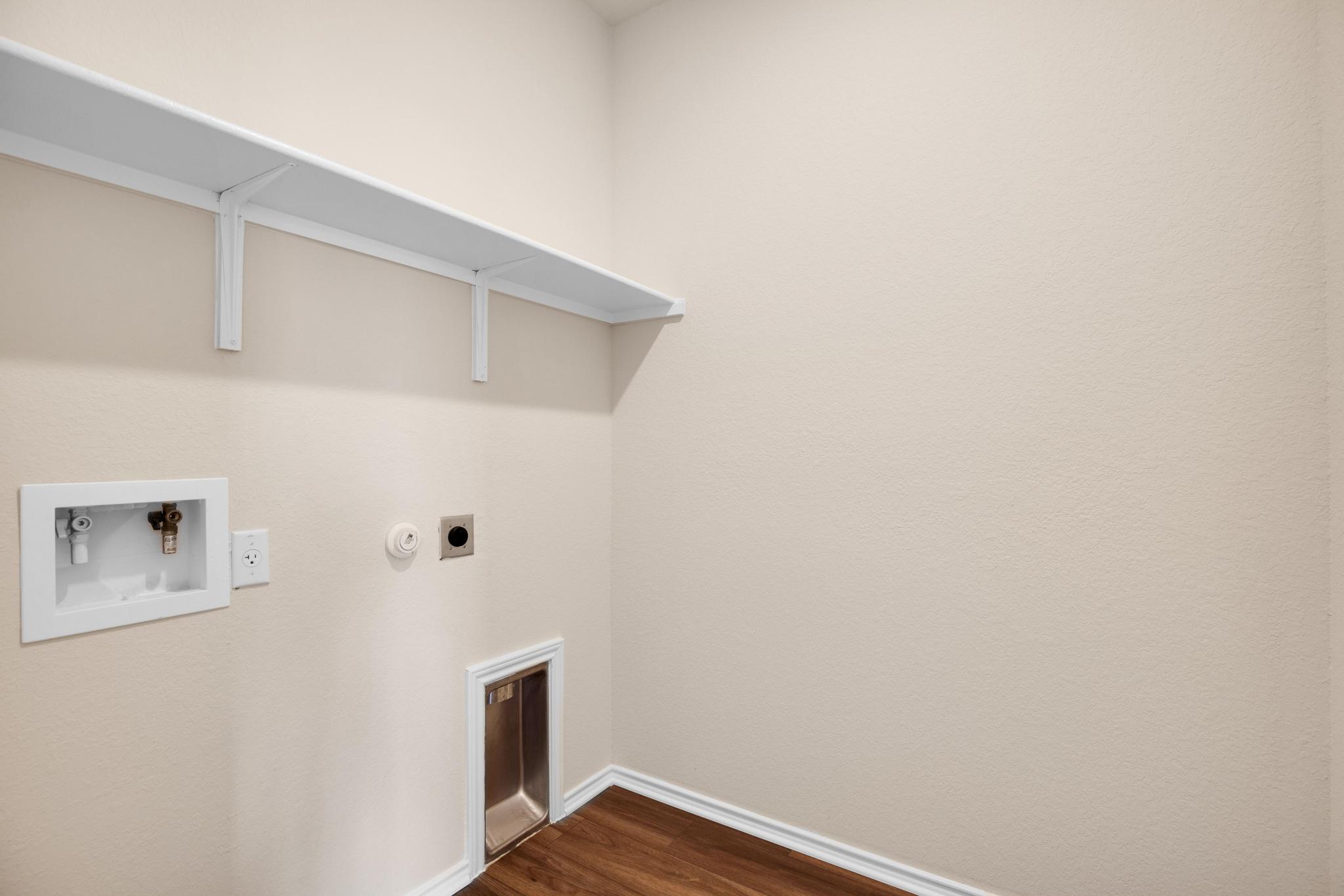 200 Janice Road Taylor, TX 76574 - Photo 15 of 25 Functional laundry space with convenient connections and shelving ready for use.