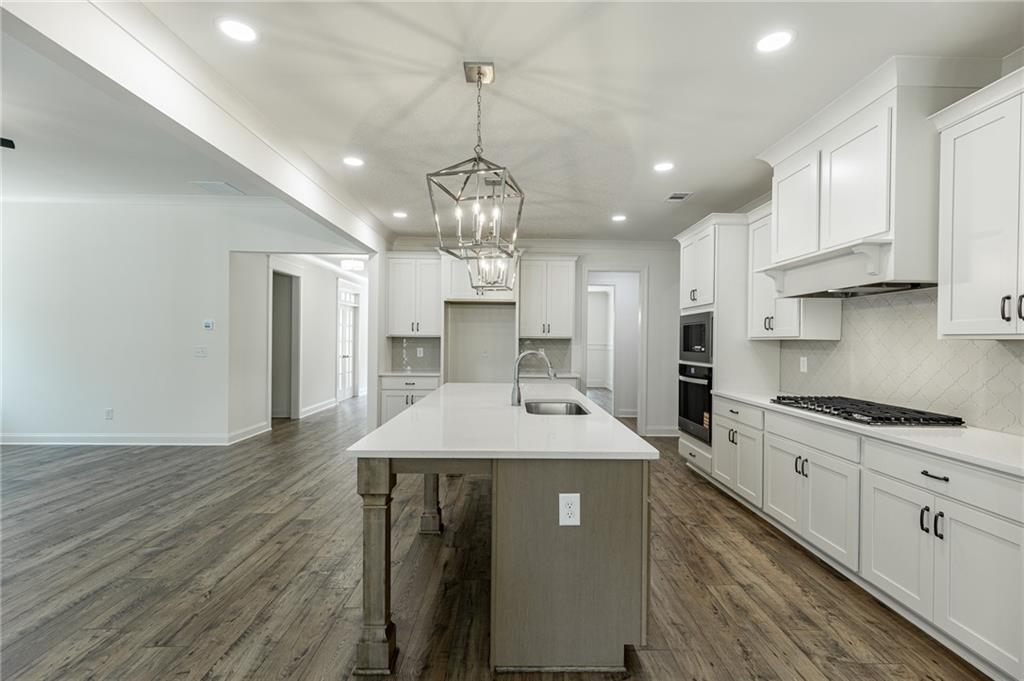 1210 Austin Road Winder, GA 30680 - Photo 16 of 56 a large kitchen with stainless steel appliances granite countertop a sink a stove and a refrigerator
