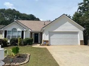 a view of a white house next to a yard and potted plants