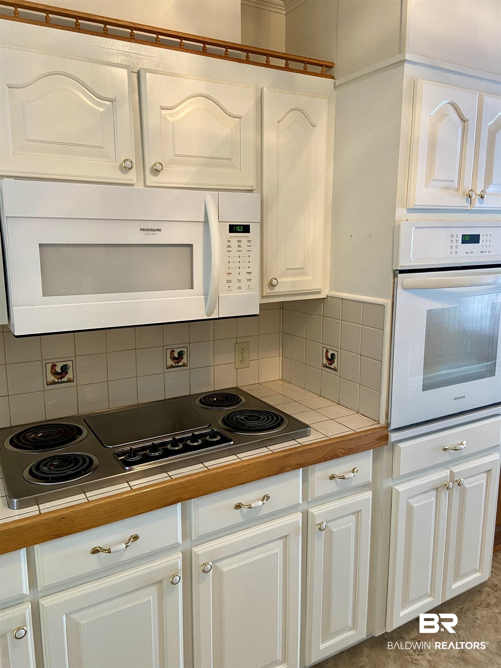 102 Ashley Street Evergreen, AL 36401 - Photo 3 of 26 Kitchen featuring white cabinetry, backsplash, tile countertops, and white appliances