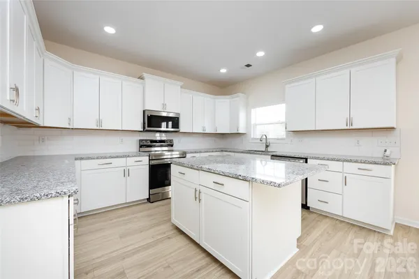 a kitchen with a sink cabinets and wooden floor
