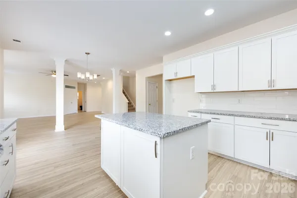 a kitchen with granite countertop white cabinets and white appliances