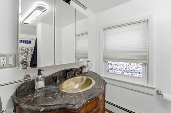 a bathroom with a granite countertop sink a mirror and a window