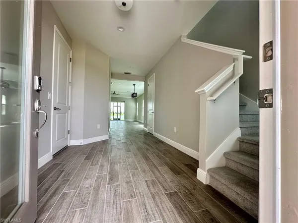 a view of a hallway with wooden floor and entryway