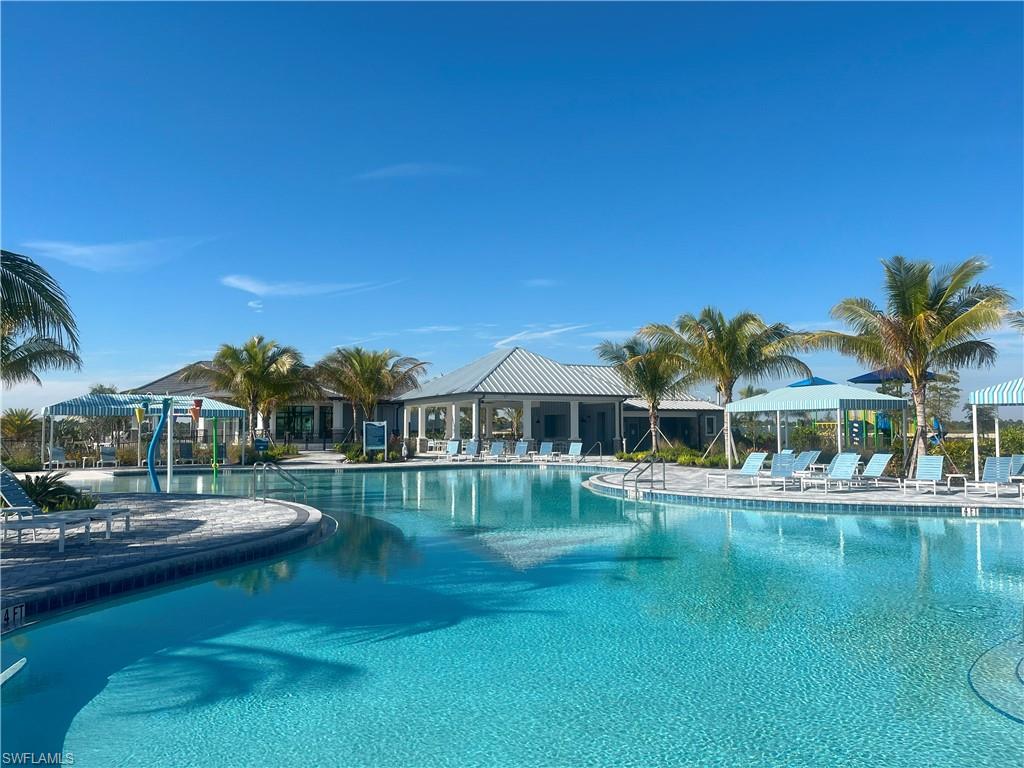 4580 Centaurus Circle Naples, FL 34120 - Photo 21 of 25 a front view of a house with a garden and lake view