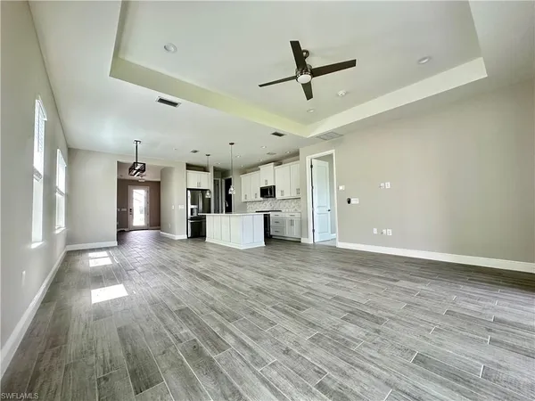 a view of large kitchen with stainless steel appliances granite countertop a stove a sink dishwasher and a oven with wooden floor