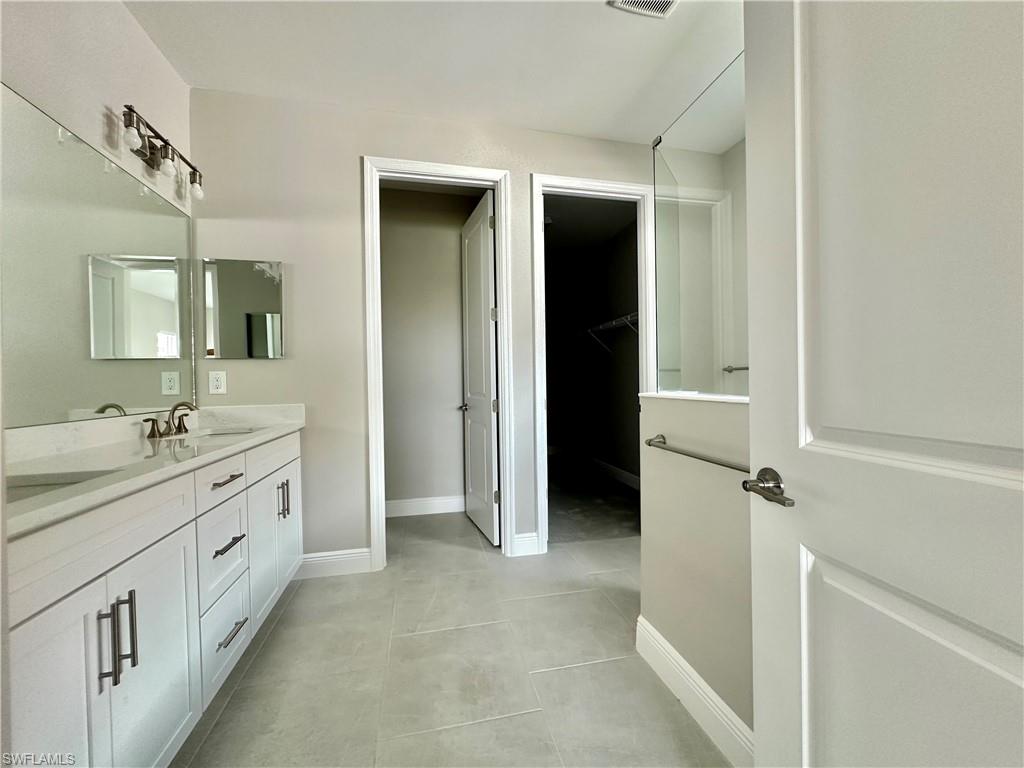 4580 Centaurus Circle Naples, FL 34120 - Photo 8 of 25 a spacious bathroom with a double vanity sink and mirror