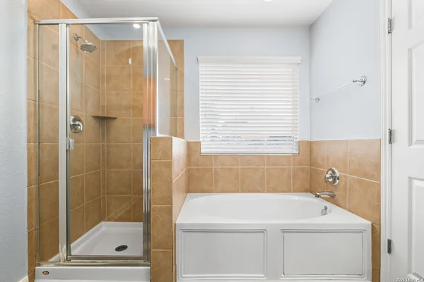 a bathroom with a shower a sink and a window