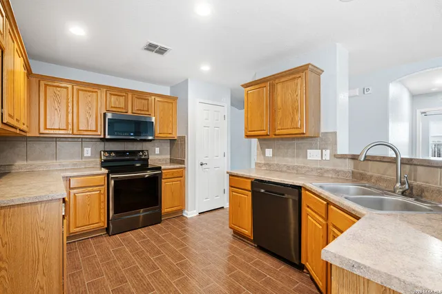 a kitchen with stainless steel appliances granite countertop a sink stove and microwave
