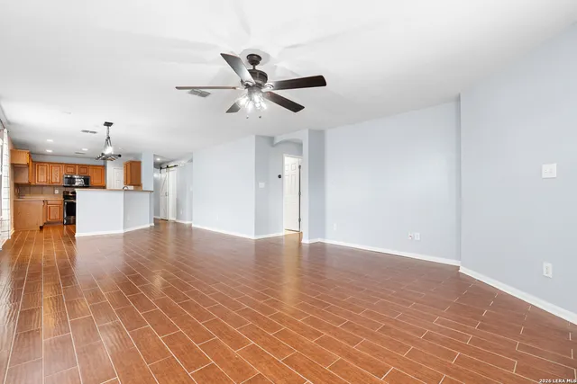 a view of empty room with wooden floor and window