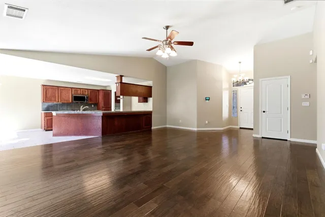 a view of a kitchen with wooden floor and a kitchen space