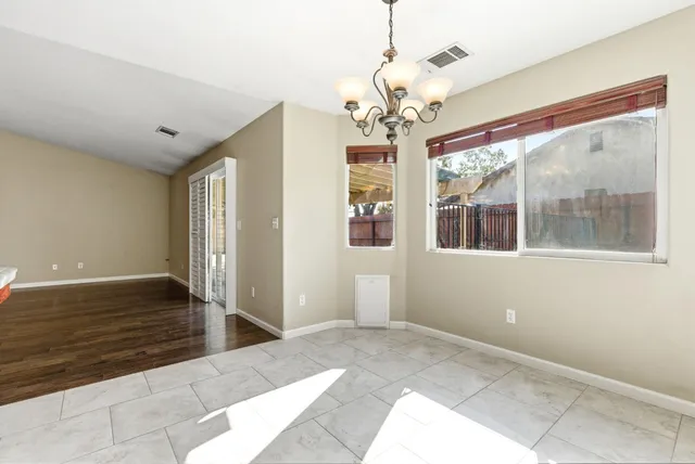 a view of a livingroom with a chandelier fan and windows
