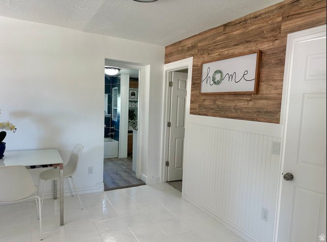 1050 West 100 North Provo, UT 84601 - Photo 5 of 16 Interior space featuring white tile flooring, beadboard wainscoting, and a wood-finish accent wall