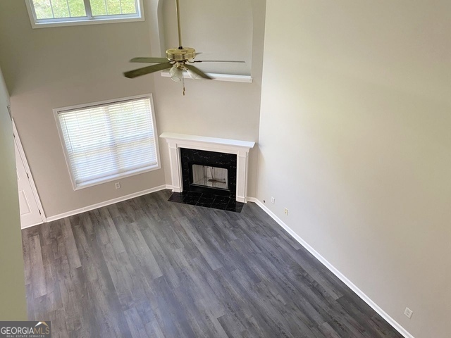 646 Lakes Circle Lithonia, GA 30058 - Photo 17 of 32 a view of an empty room with wooden floor fireplace and a window