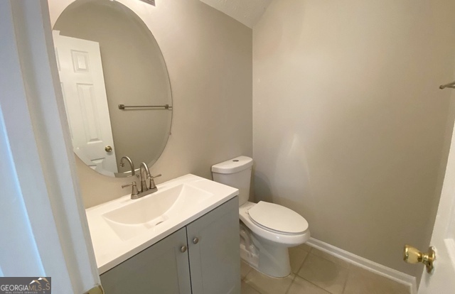 646 Lakes Circle Lithonia, GA 30058 - Photo 32 of 32 a bathroom with a sink a toilet and mirror