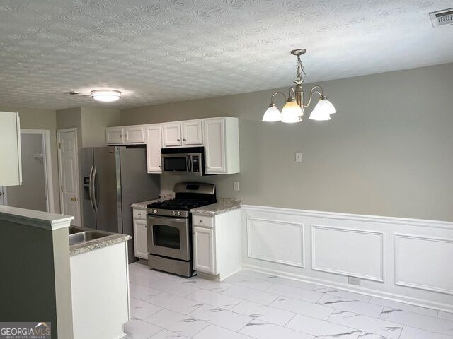 646 Lakes Circle Lithonia, GA 30058 - Photo 9 of 32 a kitchen with cabinets a sink and stainless steel appliances