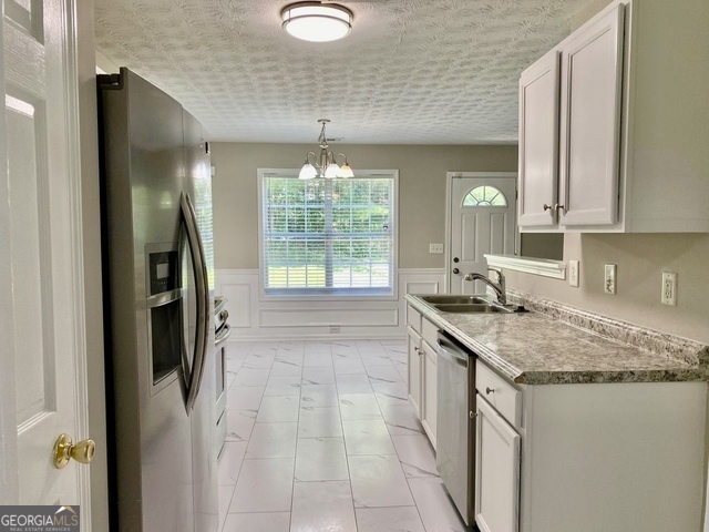 646 Lakes Circle Lithonia, GA 30058 - Photo 10 of 32 a kitchen with a sink stove and refrigerator