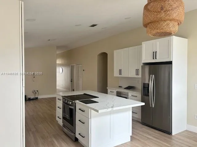 a kitchen with a stove a refrigerator and a wooden floor