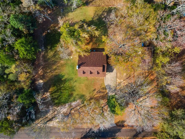 a front view of house with yard and trees around
