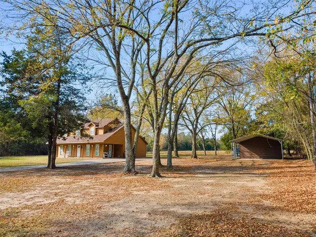 a front view of a house with a garden and tree