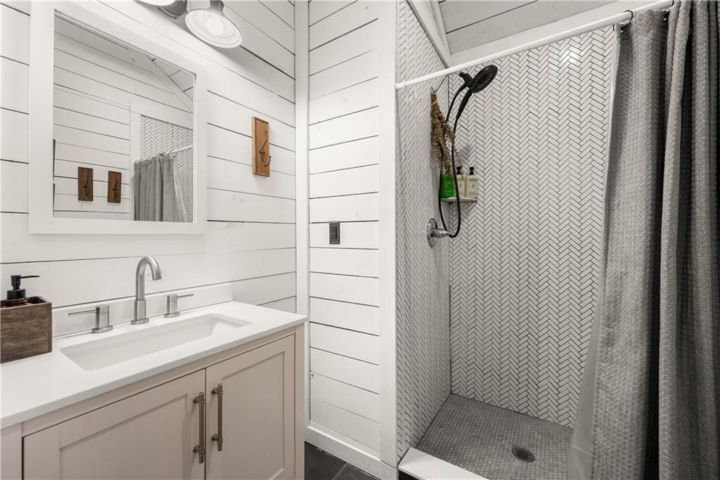 121 Waterfalls Way Clarkesville, GA 30523 - Photo 28 of 60 a bathroom with a shower sink and mirror