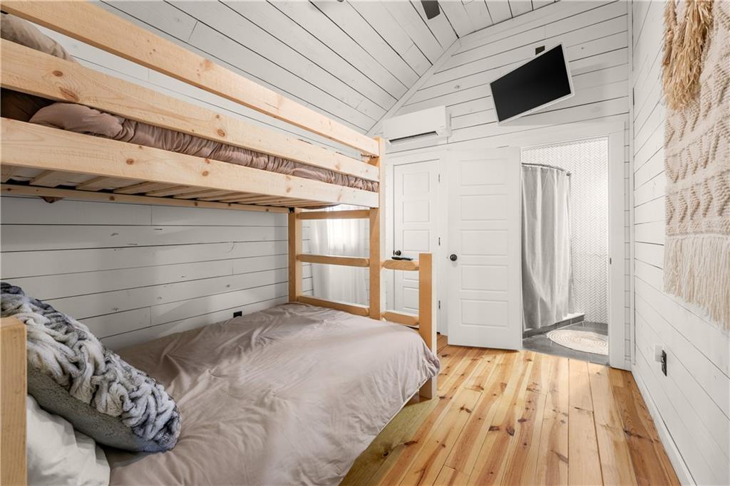 121 Waterfalls Way Clarkesville, GA 30523 - Photo 33 of 60 a bedroom with a bed and a flat tv screen