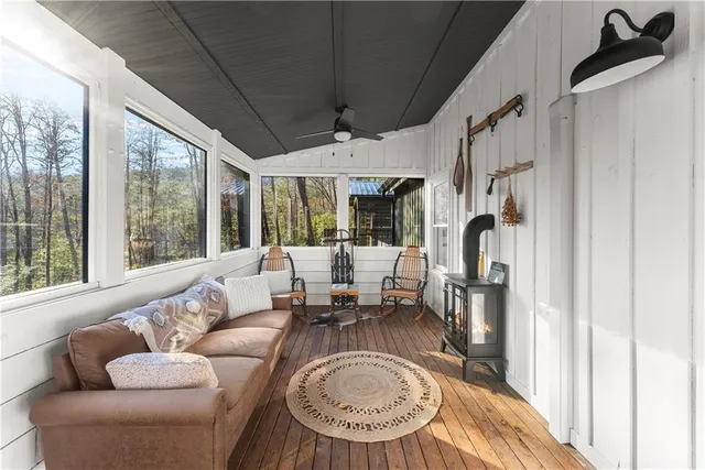 a view of wooden house with a small yard and wooden fence