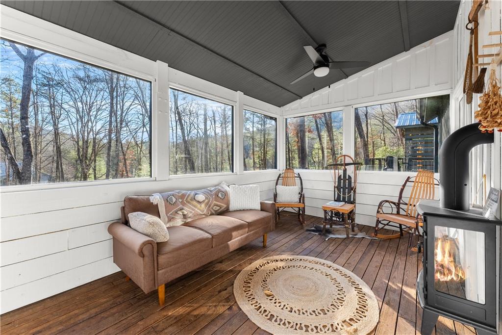 121 Waterfalls Way Clarkesville, GA 30523 - Photo 37 of 60 a living room with furniture a fireplace and a floor to ceiling window