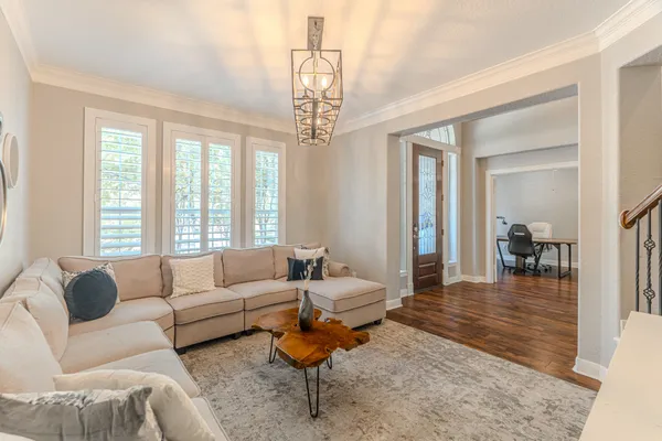 a living room with furniture a dining table and a chandelier