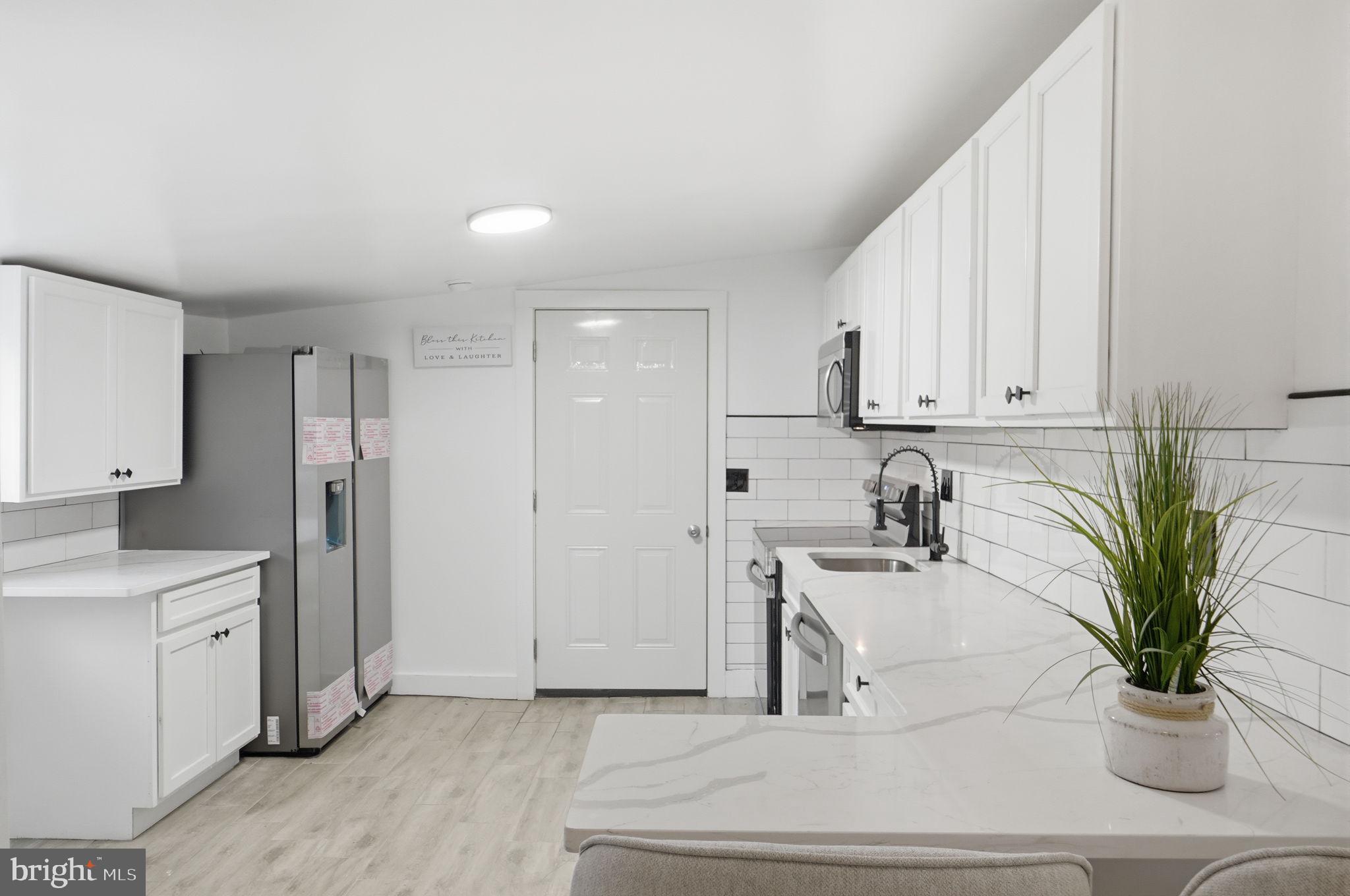 5906 Berwyn Road College Park, MD 20740 - Photo 11 of 46 a kitchen with stainless steel appliances kitchen island a refrigerator a sink a stove and white cabinets