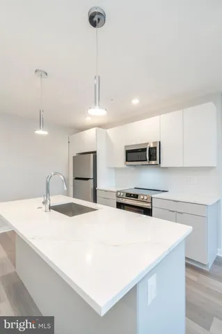 a kitchen with stainless steel appliances granite countertop a sink a stove and a refrigerator