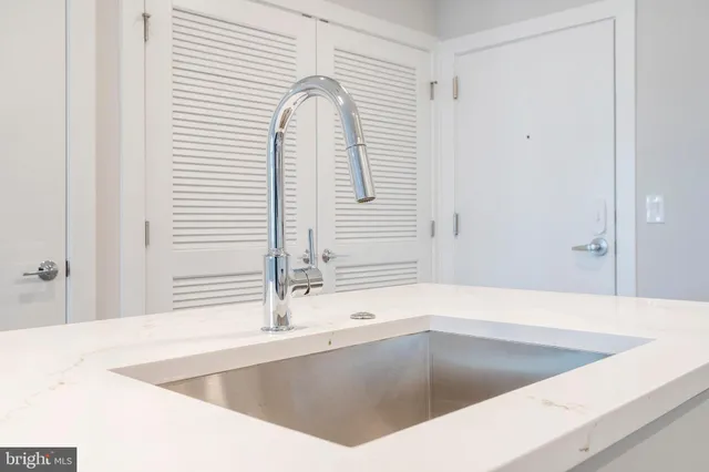 a view of a kitchen counter top a sink and cabinets