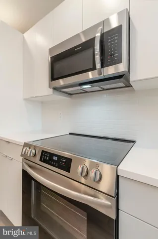 a stove top oven sitting inside of a kitchen