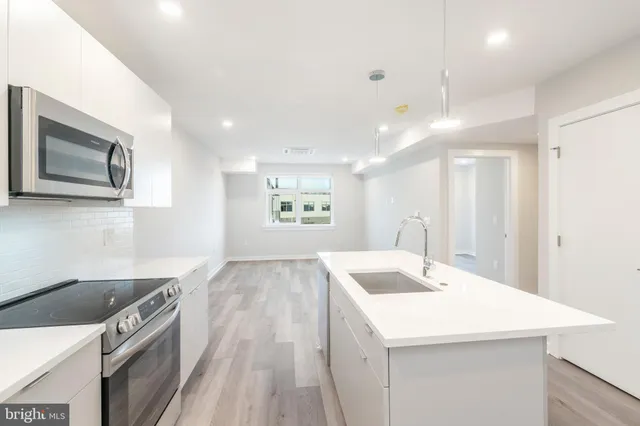 a kitchen with a sink a stove and a refrigerator