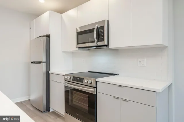a kitchen with stainless steel appliances white cabinets and a stove