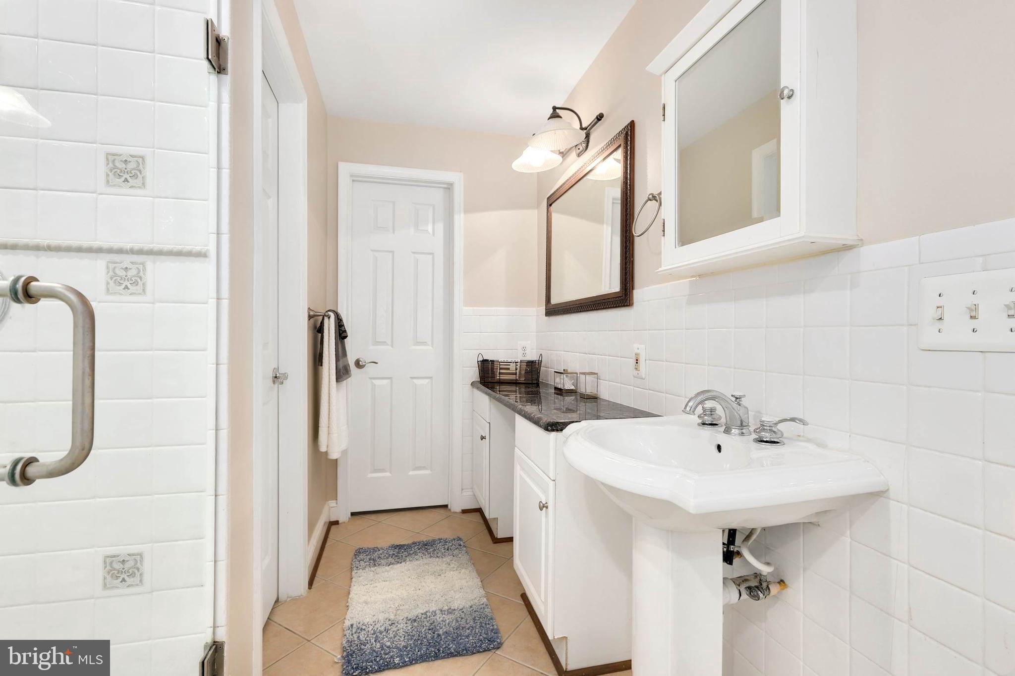 4 High Street Round Hill, VA 20141 - Photo 17 of 51 a bathroom with a sink a mirror and a shower