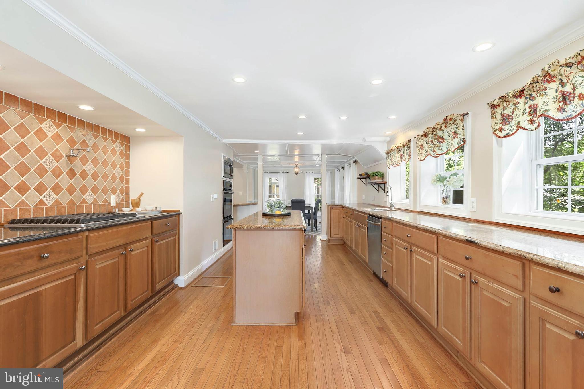 4 High Street Round Hill, VA 20141 - Photo 22 of 51 a large white kitchen with wooden floor and stainless steel appliances