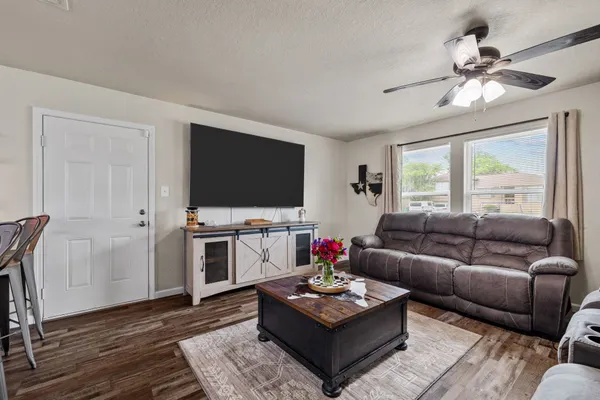 a living room with furniture a flat screen tv and a window