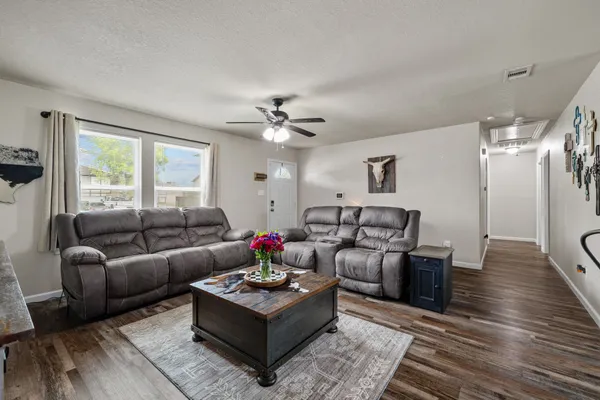 a living room with furniture and a wooden floor