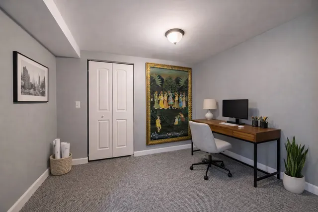 a view of a workspace with furniture and a window