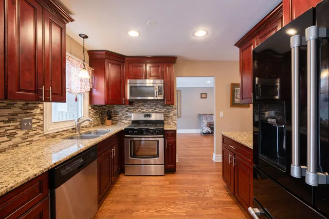 a kitchen with stainless steel appliances granite countertop wooden cabinets a sink and a stove
